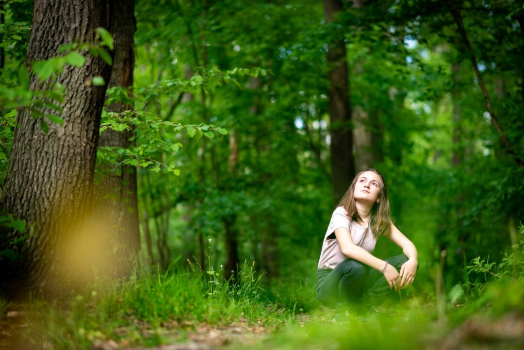 woman in white shirt standing on green grass field during daytime